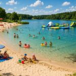Zone de baignade sur un étang avec plage et jeux gonflables, surveillée pour garantir la qualité de l’eau